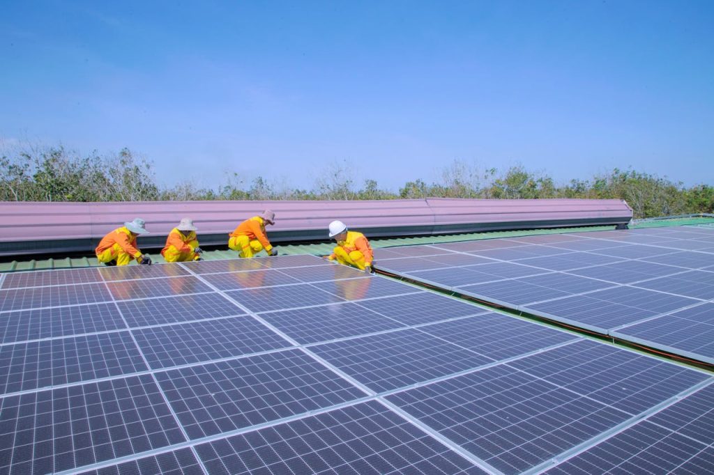 Workers installing solar panels on a sunny day, promoting renewable energy and sustainability.